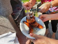 Powiększ zdjęcie: Kiełbaski upieczone na grillu w ogrodzie przy Klubie Seniora w Komorowicach podczas pikniku