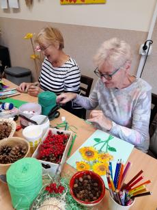 Powiększ zdjęcie: Panie z Klubu w Komorowicach podczas warsztatów manualnych, malują jesienne kwiaty