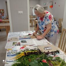 Powiększ zdjęcie: Seniorka z Dziennego Domu Senior+ wałkuje glinę podczas zajęć ceramicznych