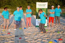 Powiększ zdjęcie: Seniorki podczas zawodów sportowych (biegi z hula hop) na plaży w Niechorzu