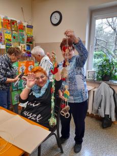 Powiększ zdjęcie: Seniorki z Klubu w Komorowicach podczas warsztatów manualnych, przygotowują  ozdobne sznurki