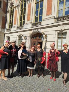 Powiększ zdjęcie: Seniorki z Klubu w Komorowicach w sukniach w stylu lat dwudziestych przed zamkiem w Pszczynie