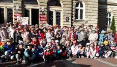 Powiększ zdjęcie: Seniorzy w ozdobnych nakryciach głowy podczas Parady Kapeluszy.