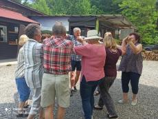 Powiększ zdjęcie: Seniorzy z Dziennego Domu Senior+ tanczą podczas spotkania plenerowego