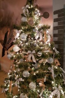 Powiększ zdjęcie: Udekorowana choinka na ktorej wiszą ruloniki z zapisanymi marzeniami seniorow.