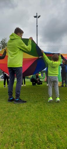 Powiększ zdjęcie: Zdjęcie przedstawia bawiących się chłopców w zielonych bluzach