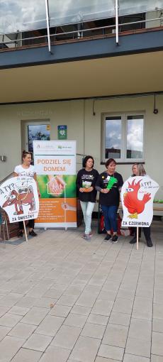 Powiększ zdjęcie: Zdjęcie przedstawia cztery kobiety promujące projekt „Podziel się domem” i projekt „Za jaki”