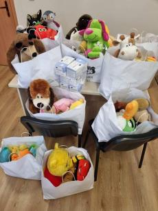 Powiększ zdjęcie: Zdjęcie przedstawia mnóstwo kolorowych maskotek i 5 pudełek maseczek ochronnych