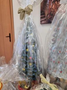 Powiększ zdjęcie: Zdjęcie przedstawia sztuczna zielona choinkę ozdobiona niebieskim łańcuszkiem.