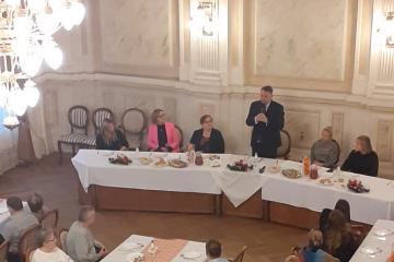 Prezydent Miasta Bielska-Białej przemawiający do osób zebranych przy wigilijnym stole.