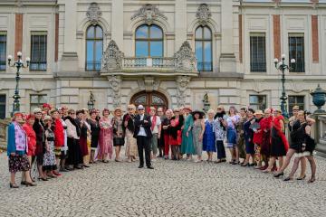 Seniorzy z OWOS przed zamkiem w Pszczynie, w strojach z lat dwudziestych dwudziestego wieku