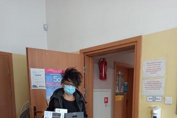  Zdjęcie przedstawia Panią pełniącą funkcję rodziny zastępczej, która trzyma w rękach otrzymany w ramach projektu zestaw komputerowy.